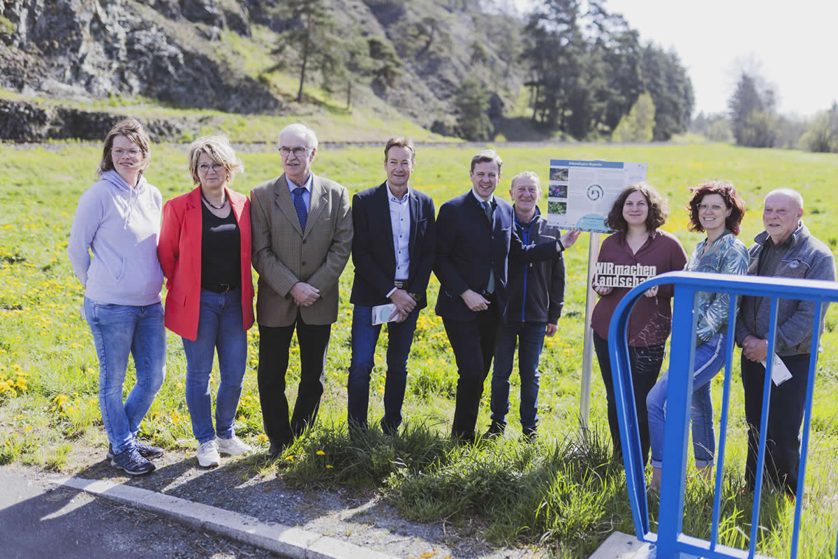 Landrat Oliver Bär und Isabel Kaske (an der Infotafel) bei der Einweihung des neuen Rundwanderwegs. Auch Regina Saller vom Landschaftspflegeverband, zweiter Bürgermeister Rudolf Scholz aus Rehau, Bürgermeister Stefan Breuer aus Oberkotzau (von links) sowie Annette Bauer vom Landschaftspflegeverband (Zweite von rechts) freuen sich mit weiteren Teilnehmern über das neue Naturerlebnis bei Woja (Foto: Landkreis Hof).